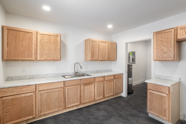 kitchen featuring electric water heater, light brown cabinetry, and sink