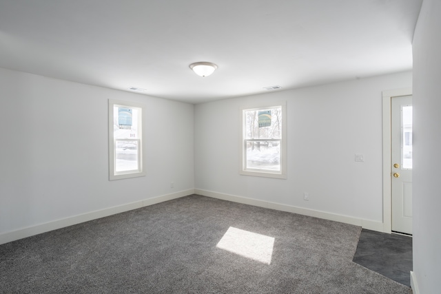 spare room featuring dark colored carpet