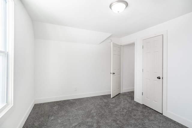 unfurnished bedroom with dark carpet