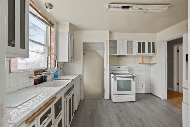 kitchen featuring white appliances, light wood-style floors, white cabinetry, open shelves, and a sink