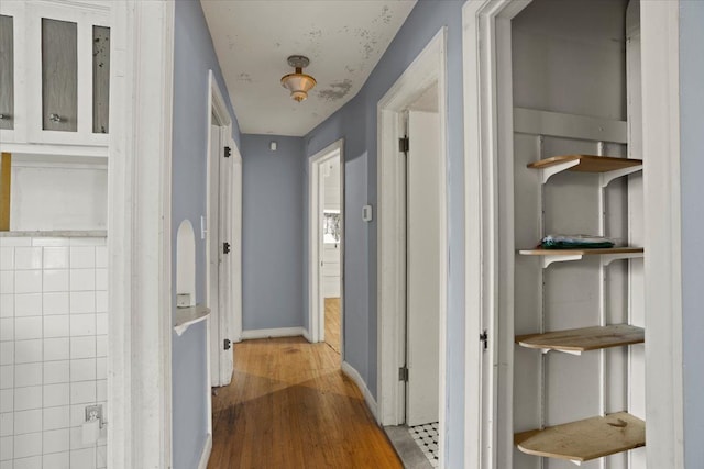 hall featuring wood finished floors and baseboards