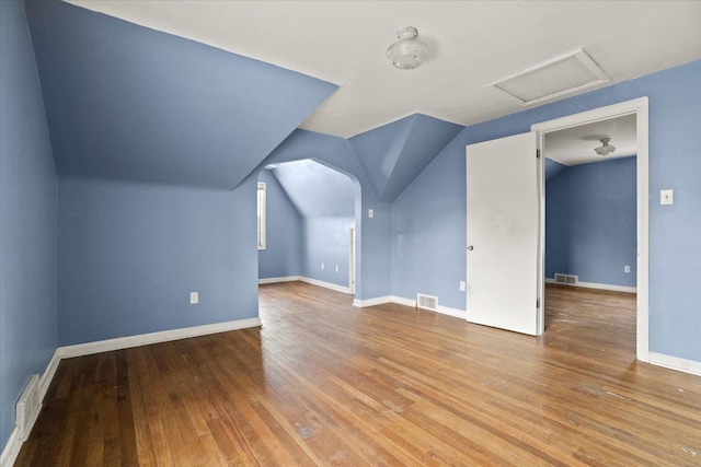 bonus room featuring baseboards, attic access, visible vents, and wood finished floors