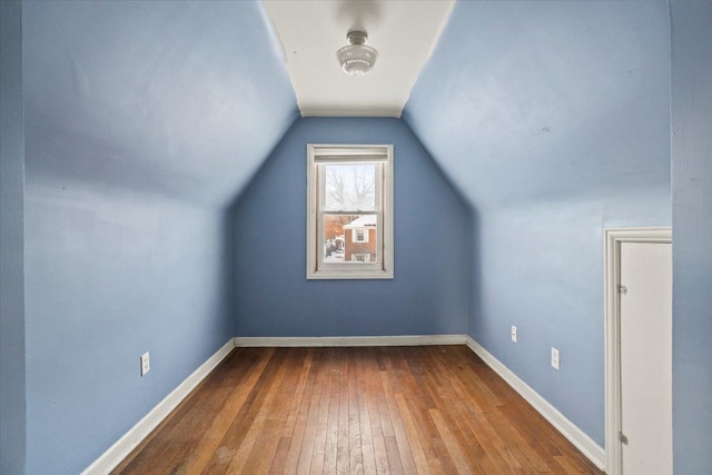 additional living space with lofted ceiling, baseboards, and wood finished floors