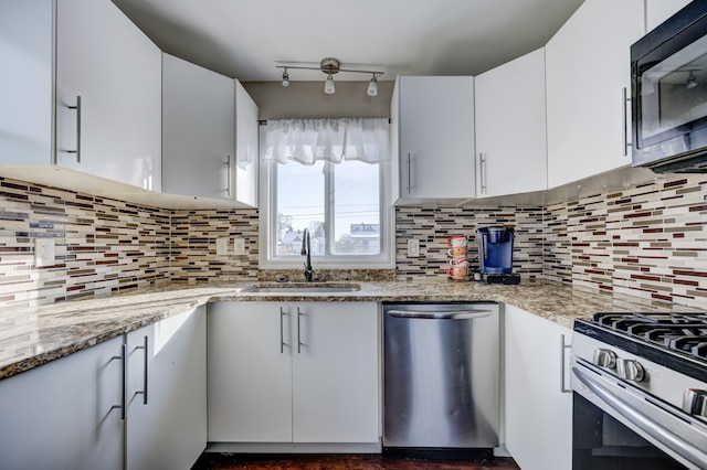 kitchen featuring white cabinets, stainless steel appliances, light stone countertops, and sink