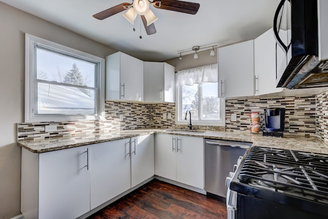 kitchen with white cabinetry, appliances with stainless steel finishes, sink, and light stone countertops