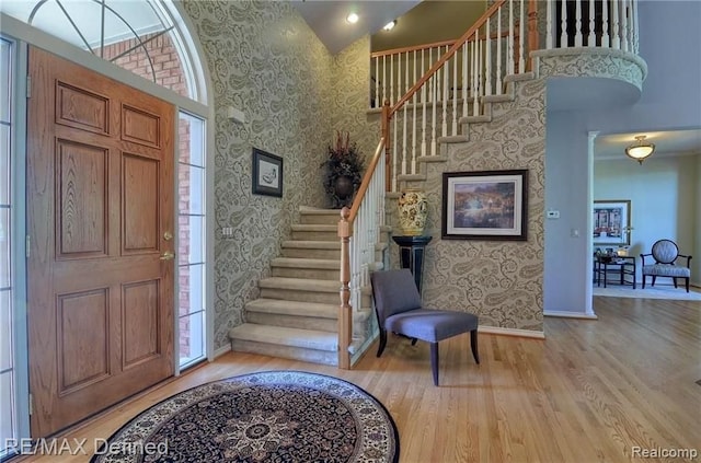 entryway with hardwood / wood-style floors and a high ceiling