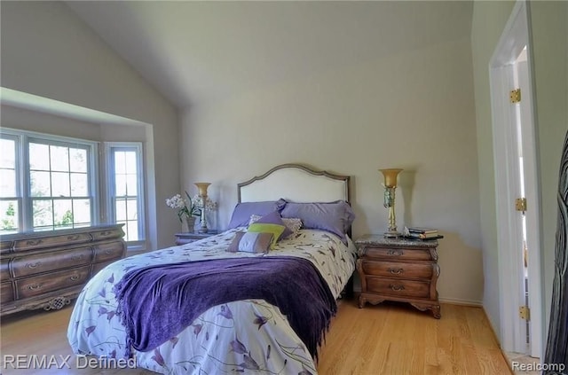 bedroom with lofted ceiling and light hardwood / wood-style floors