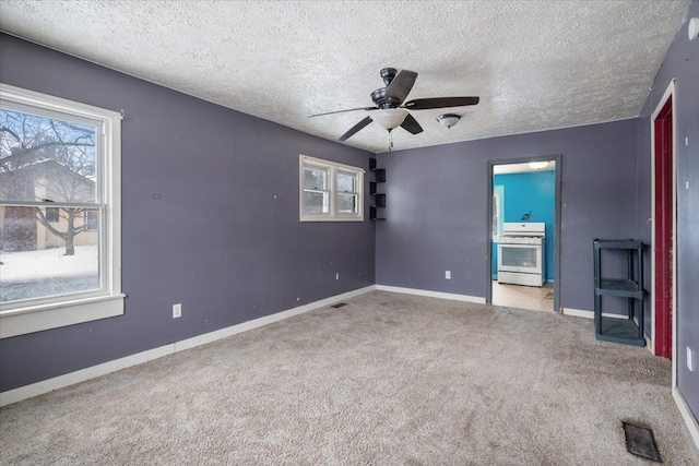 unfurnished bedroom featuring carpet floors, visible vents, ceiling fan, a textured ceiling, and baseboards