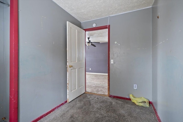 carpeted empty room with a textured ceiling and baseboards