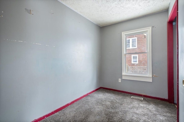 unfurnished room featuring baseboards, visible vents, a textured ceiling, and carpet flooring