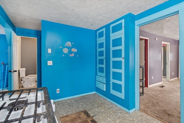 unfurnished bedroom featuring carpet floors, visible vents, baseboards, and a textured ceiling