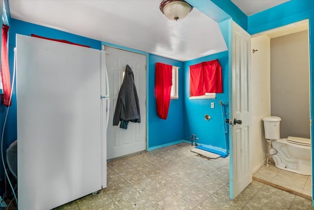 bathroom with tile patterned floors, toilet, and baseboards