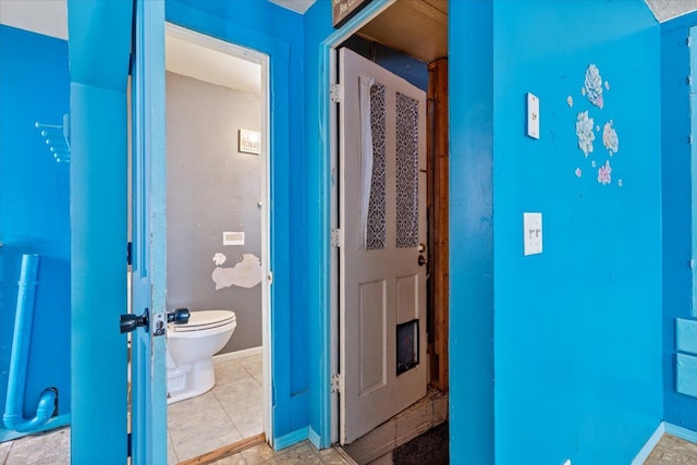 bathroom with tile patterned floors, toilet, and baseboards