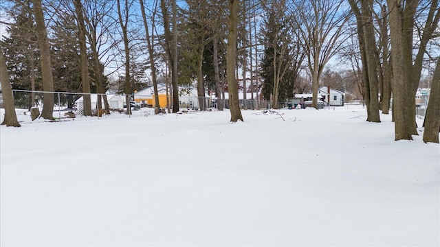 yard layered in snow featuring fence