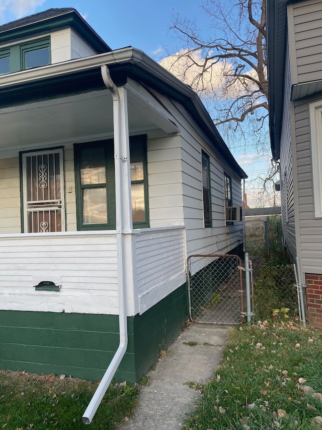 view of side of property with cooling unit and a gate