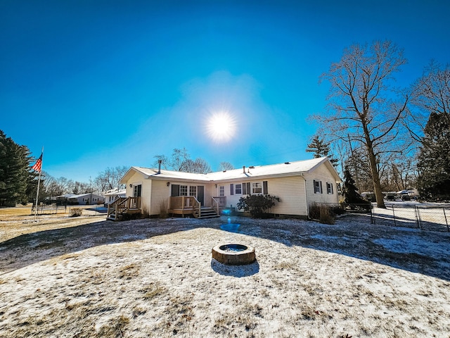 rear view of property with a fire pit