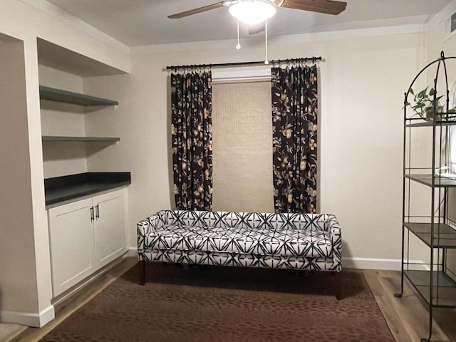 living area with baseboards, visible vents, a ceiling fan, and wood finished floors