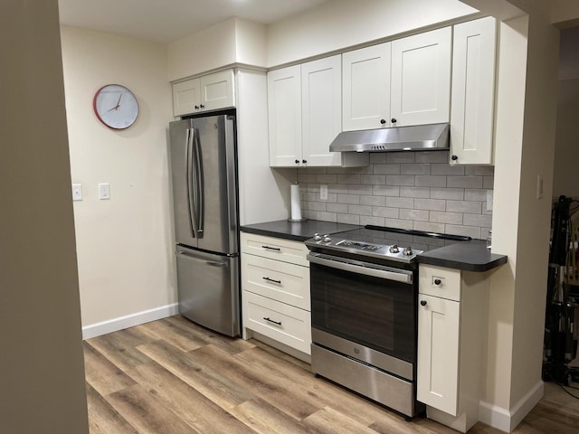 kitchen featuring appliances with stainless steel finishes, dark countertops, white cabinets, and under cabinet range hood