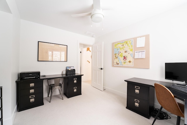 office space with baseboards, a ceiling fan, and light colored carpet