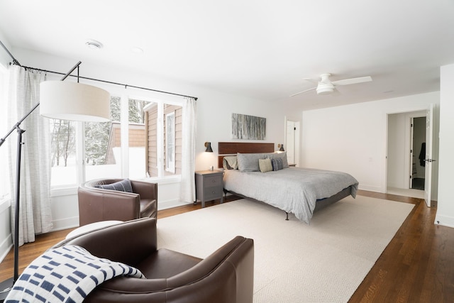 bedroom with ceiling fan, baseboards, and wood finished floors