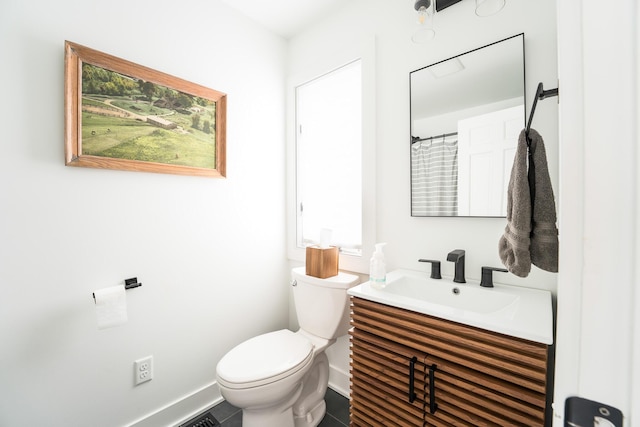 bathroom with toilet, baseboards, and vanity