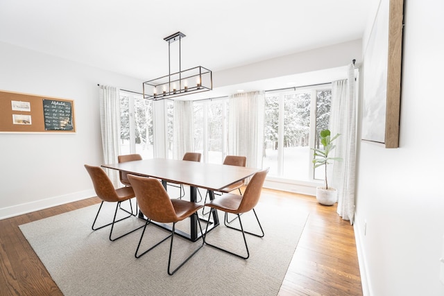 dining room featuring an inviting chandelier, baseboards, and wood finished floors