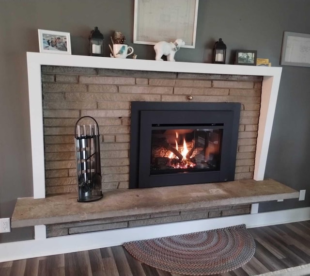 details featuring hardwood / wood-style floors and a brick fireplace