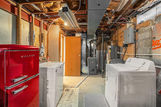 basement with heating unit, refrigerator, electric panel, washing machine and dryer, and water heater