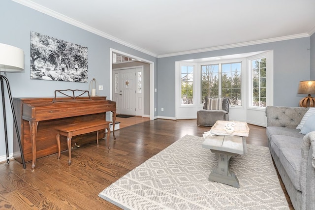 living area featuring baseboards, wood finished floors, and crown molding