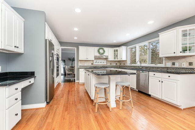 kitchen with glass insert cabinets, white cabinetry, and a kitchen island