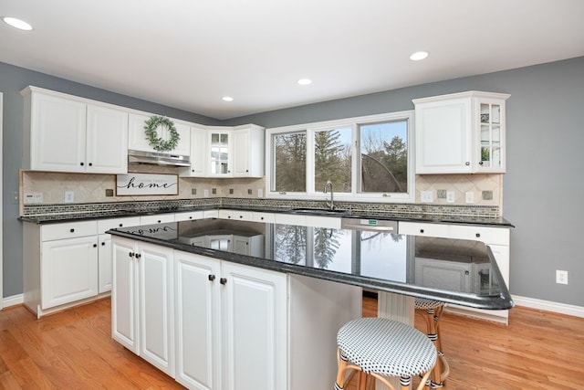 kitchen featuring glass insert cabinets, a center island, and white cabinetry