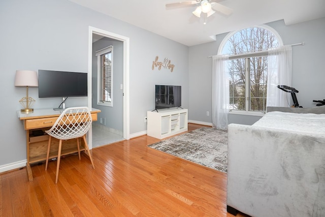 bedroom featuring a ceiling fan, baseboards, and wood finished floors