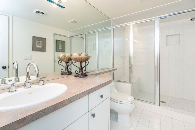 full bathroom with toilet, visible vents, a tile shower, and vanity