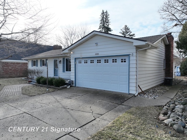 ranch-style home with a shingled roof, concrete driveway, cooling unit, a chimney, and a garage