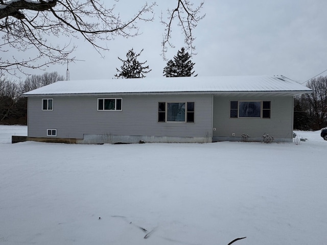 view of snow covered rear of property