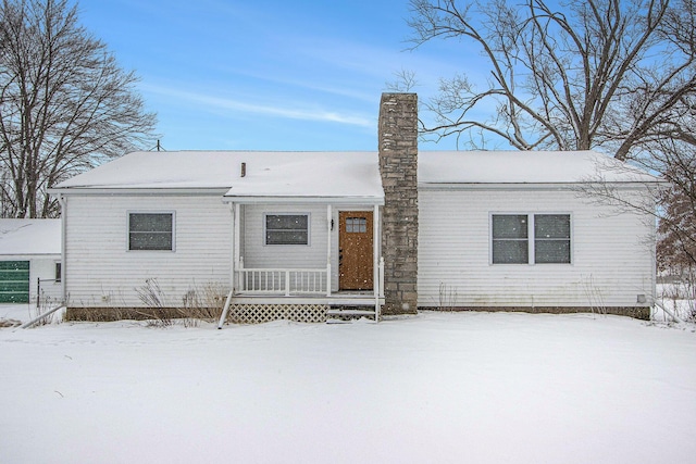 view of snow covered back of property