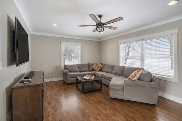 living room featuring ceiling fan, dark wood-type flooring, and a healthy amount of sunlight