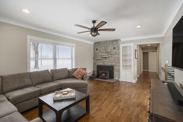 living room with built in shelves, a fireplace, dark hardwood / wood-style floors, and ceiling fan