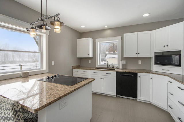 kitchen featuring sink, stone counters, white cabinetry, black appliances, and decorative light fixtures