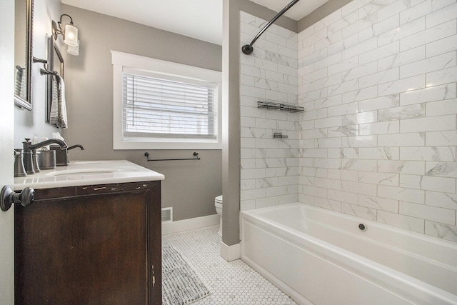 full bathroom with vanity, tiled shower / bath, tile patterned floors, and toilet