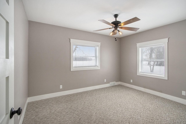 carpeted spare room with ceiling fan