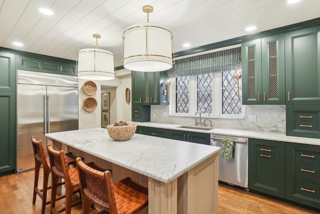 kitchen with a kitchen island, pendant lighting, sink, green cabinetry, and stainless steel appliances