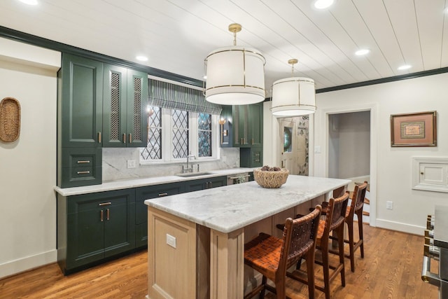 kitchen featuring a kitchen island, tasteful backsplash, sink, hanging light fixtures, and crown molding