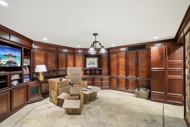 living area with an inviting chandelier and ornamental molding