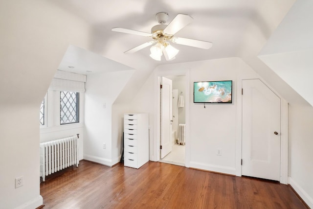 additional living space with lofted ceiling, radiator heating unit, and dark hardwood / wood-style flooring