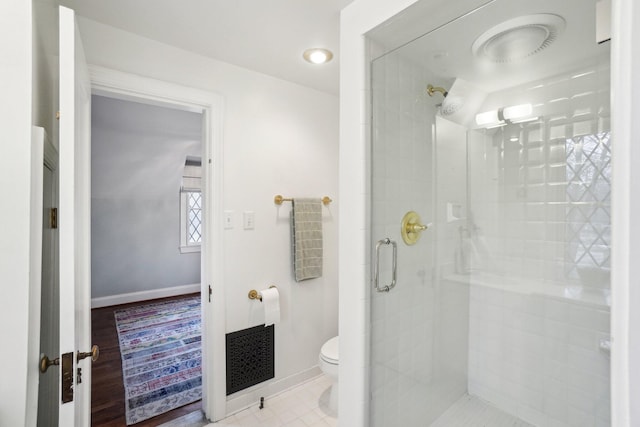 bathroom with toilet and an enclosed shower