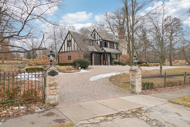 english style home featuring a garage