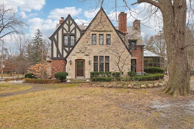 tudor-style house with a front lawn