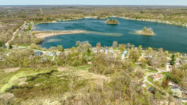 aerial view with a water view and a wooded view
