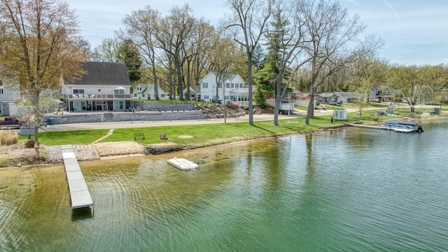 view of dock with a water view and a yard